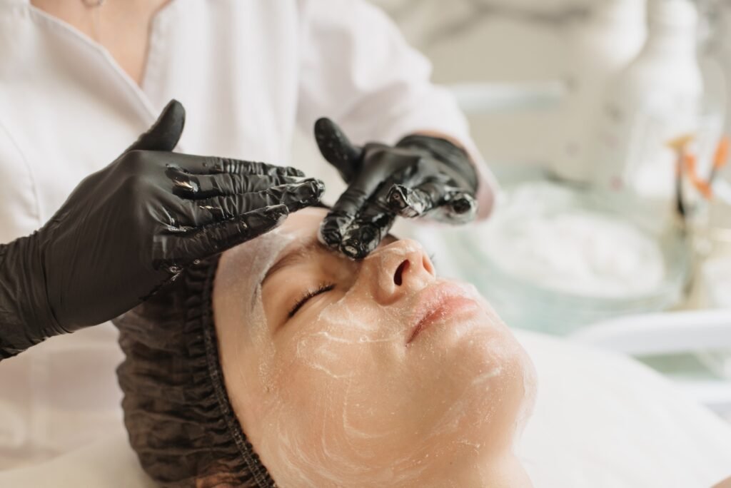 Facial peeling, skin care. A woman receiving facials from a cosmetologist at a spa, close-up