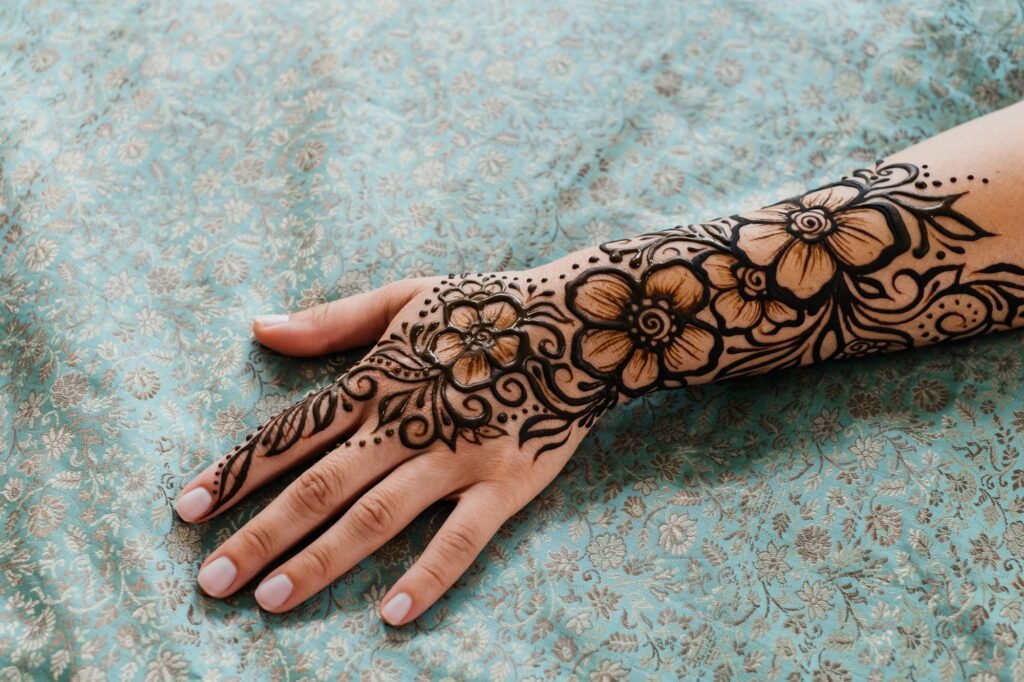 Henna tattoo on woman hands, artist drawing Arabic mehndi
