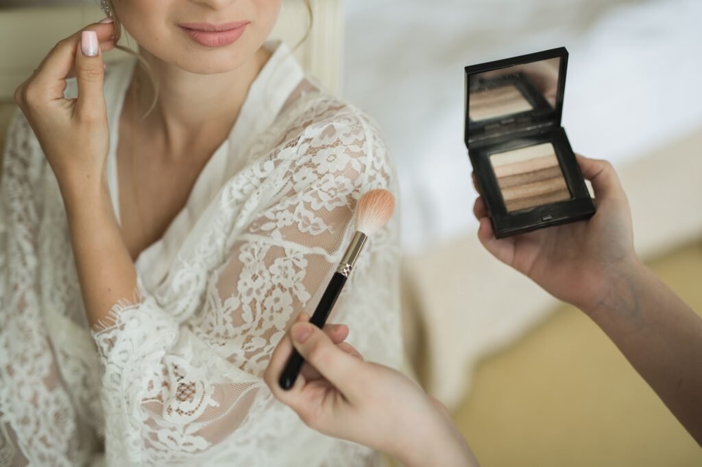makeup artist preparing bride before the wedding in a morning