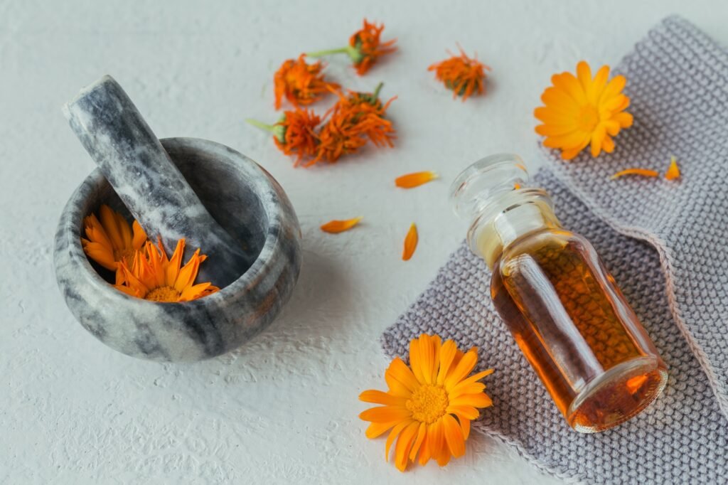 Natural cosmetic oil, tincture or infusion and mortar with Calendula flowers